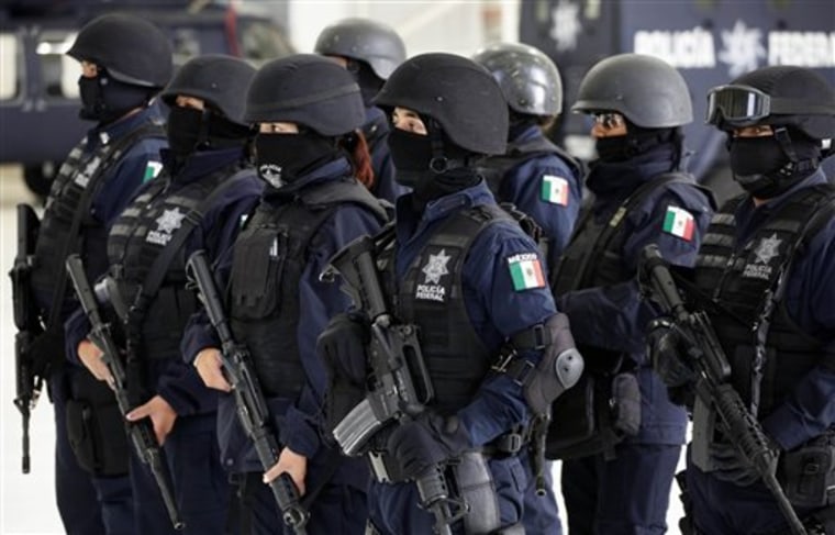 Police officers stand in formation during a presentation of drug dealing suspects to the media in Mexico City on Tuesday.